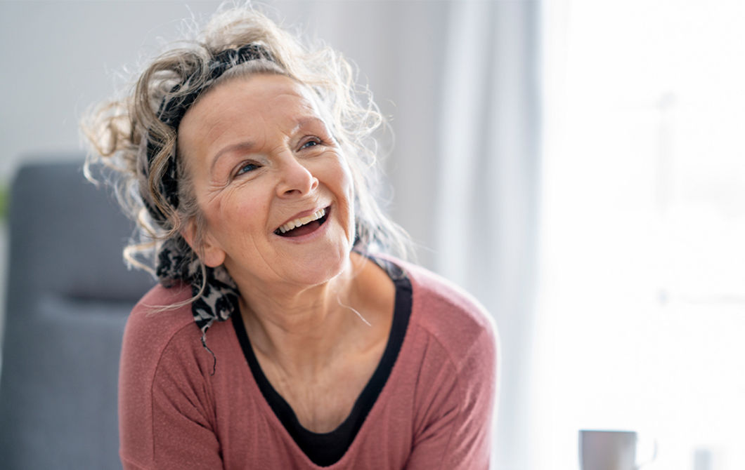 Mies istuu pöydässä kahvimuki kädessään.