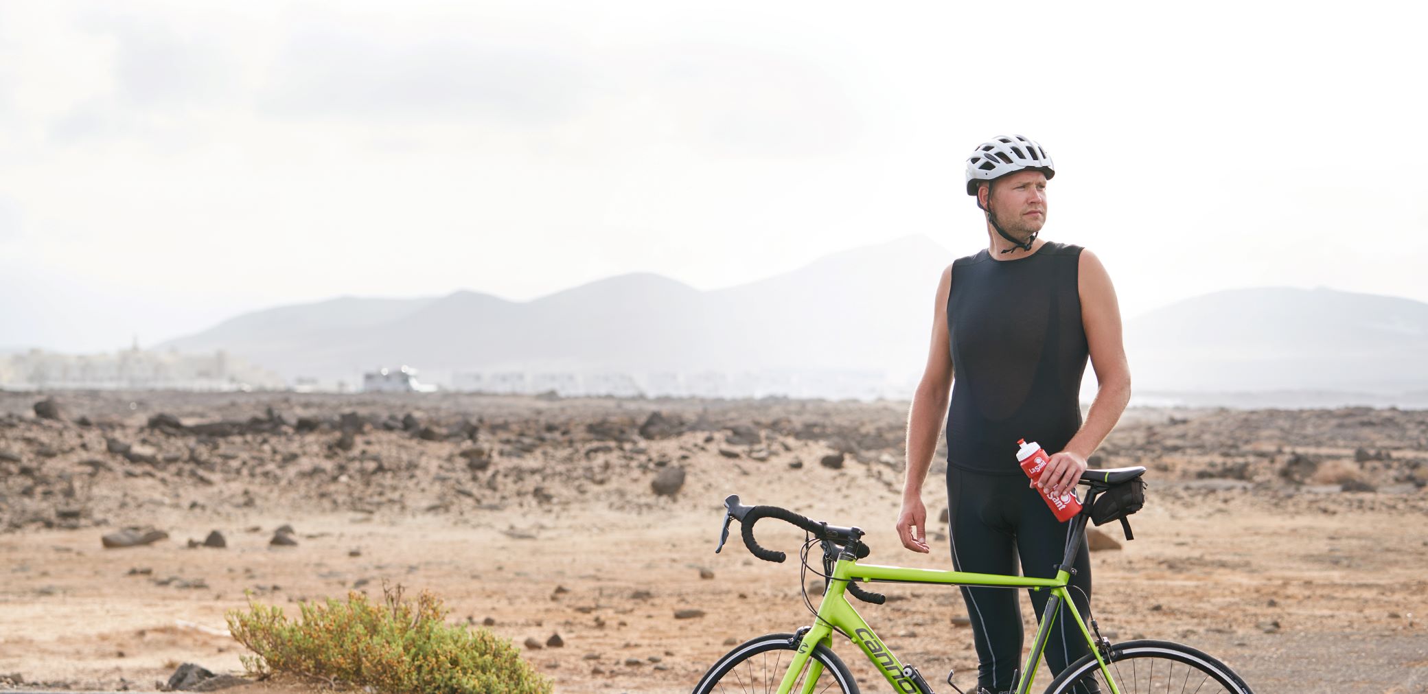 Woman biking in a street with flowers in the background.