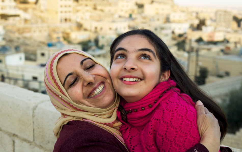 Mother and young daughter smiling at each other 