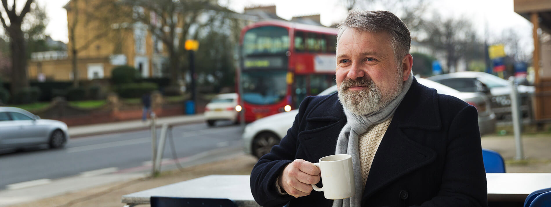 Man sitting at a table with a coffee mug in his hand.
