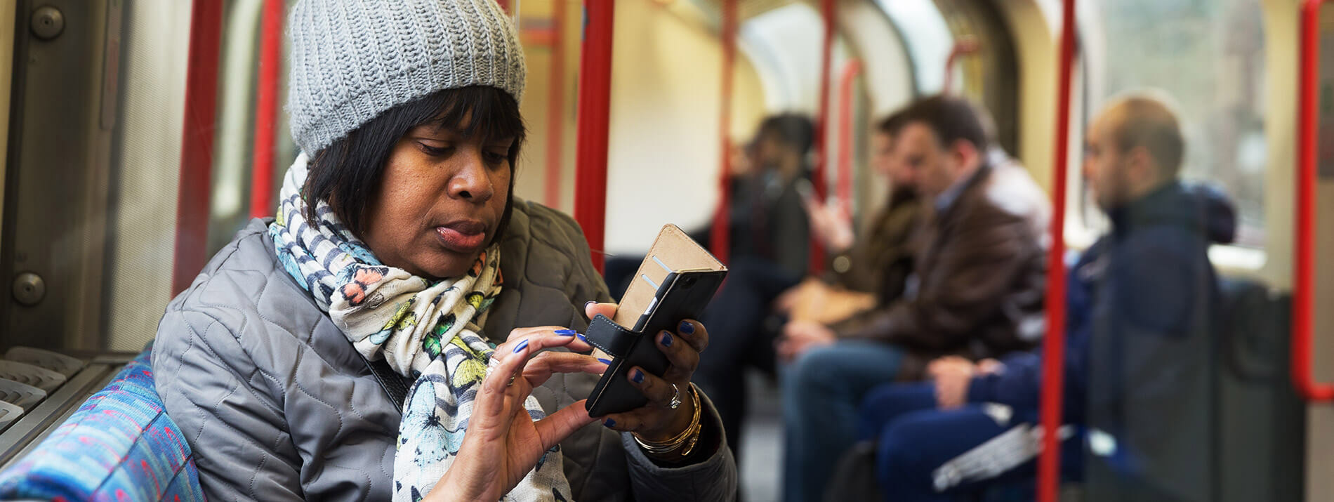 Woman sitting in a train browsing her smartphone.