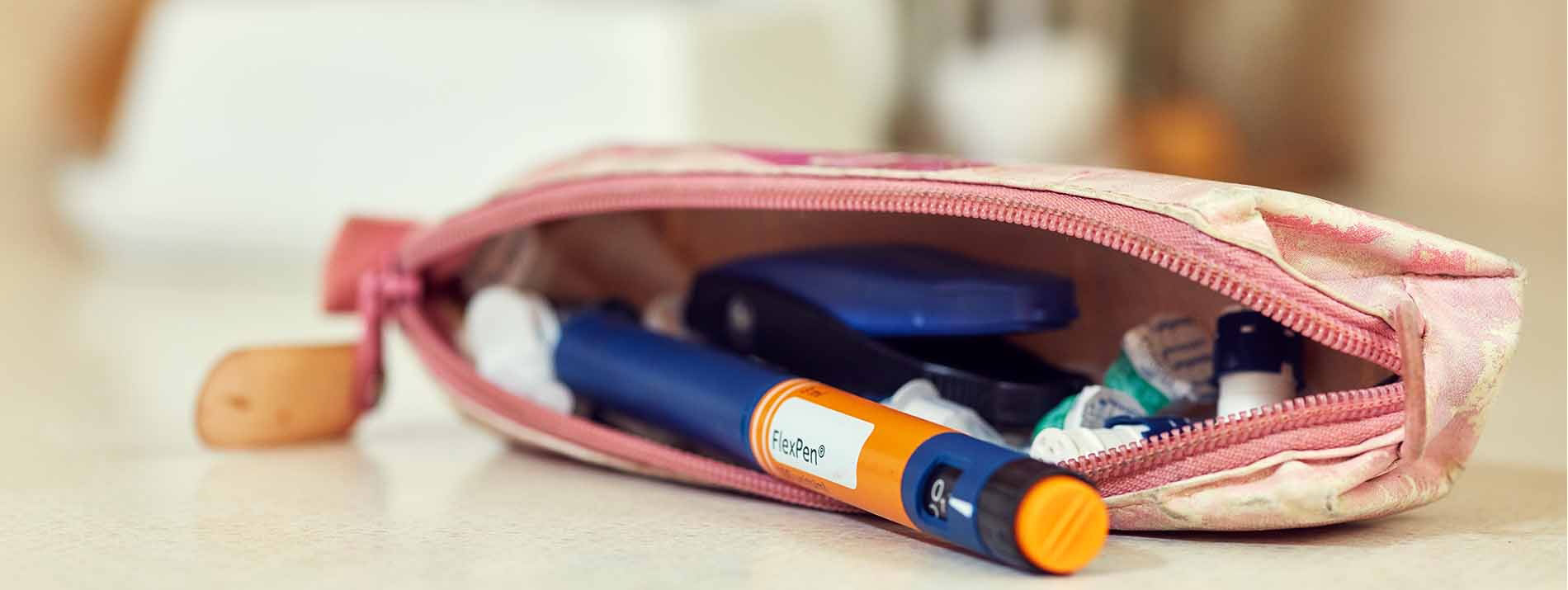 Purse laying on a table with an orange FlexPen sticking out