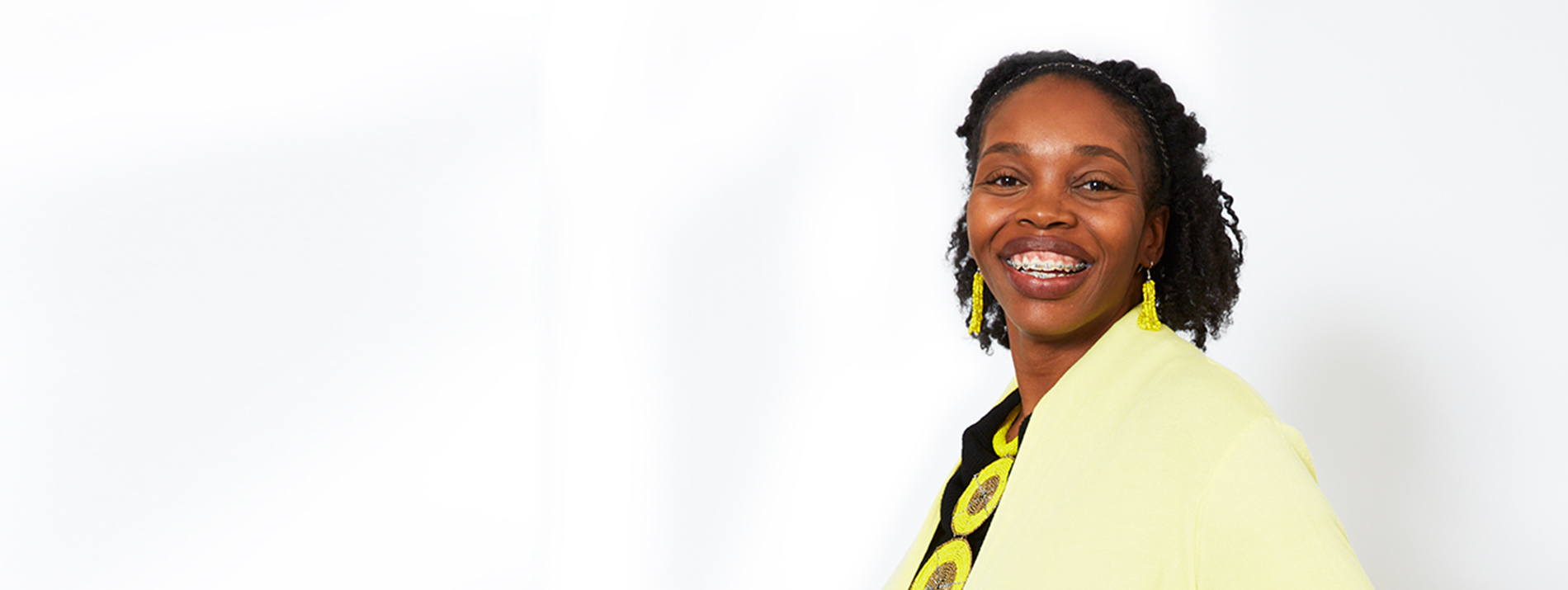 A right-aligned portrait of a woman wearing a yellow jacket.